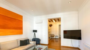 Un salon moderne avec un canapé, une table basse et un téléviseur à écran plat.