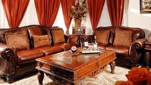 A traditional living room with a brown leather sofa set, a wooden coffee table, and red curtains. - Historic Boutique Hotel (Branson)