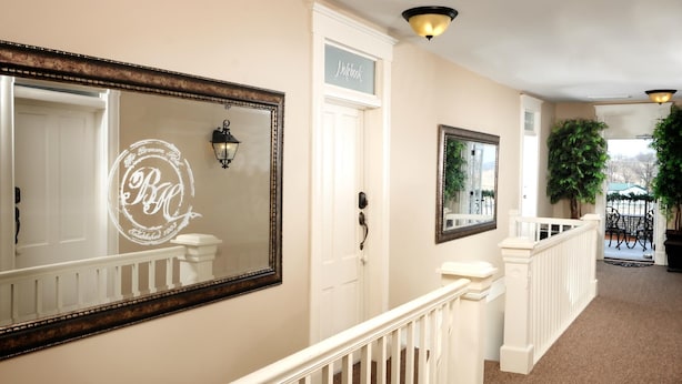 A hallway with a white door labeled "Notebook," a large mirror with a decorative frame, and a potted plant. - Historic Boutique Hotel (Branson)