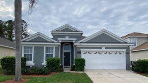 A two-story house with a front garage, a central entrance, and a symmetrical facade.