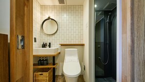 Une salle de bain moderne équipée de toilettes, d’un lavabo et d’une douche.