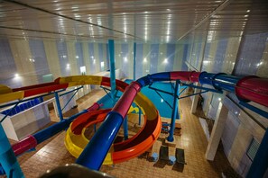 An indoor water park with multiple slides and pools. - Grand Hotel Sogdiana (Samarkand)