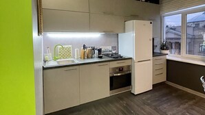 Eine moderne Küche mit Einbauofen, Kühlschrank und Fenster mit Blick auf die Stadt.