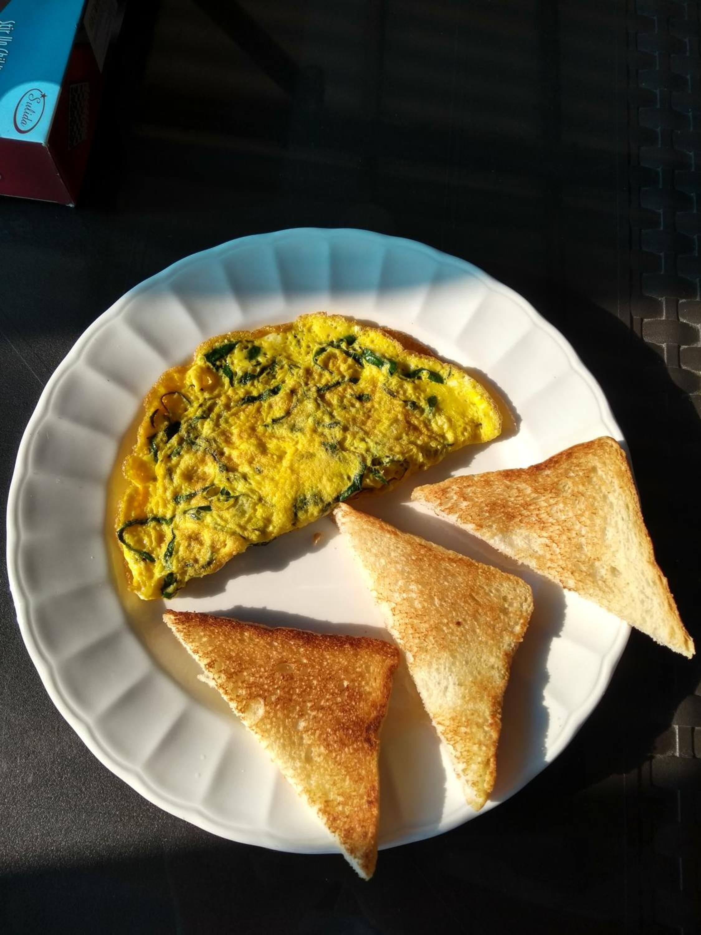 Un plato con una tortilla y dos tostadas sobre una mesa.
