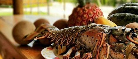 Un langostino en un plato con un paisaje tropical de fondo.