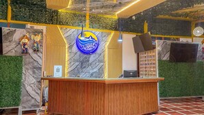 Un comptoir d’accueil avec un mur en marbre et un panneau signalétique avec le logo de l’entreprise.