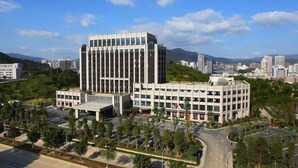 A modern building with a central tower and a flat-roofed annex. - Winlong International Hotel (Quanzhou)