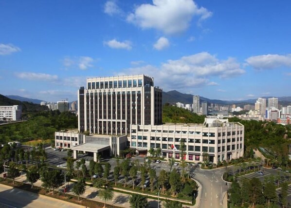 Um edifício moderno com uma torre central e um anexo com telhado plano.