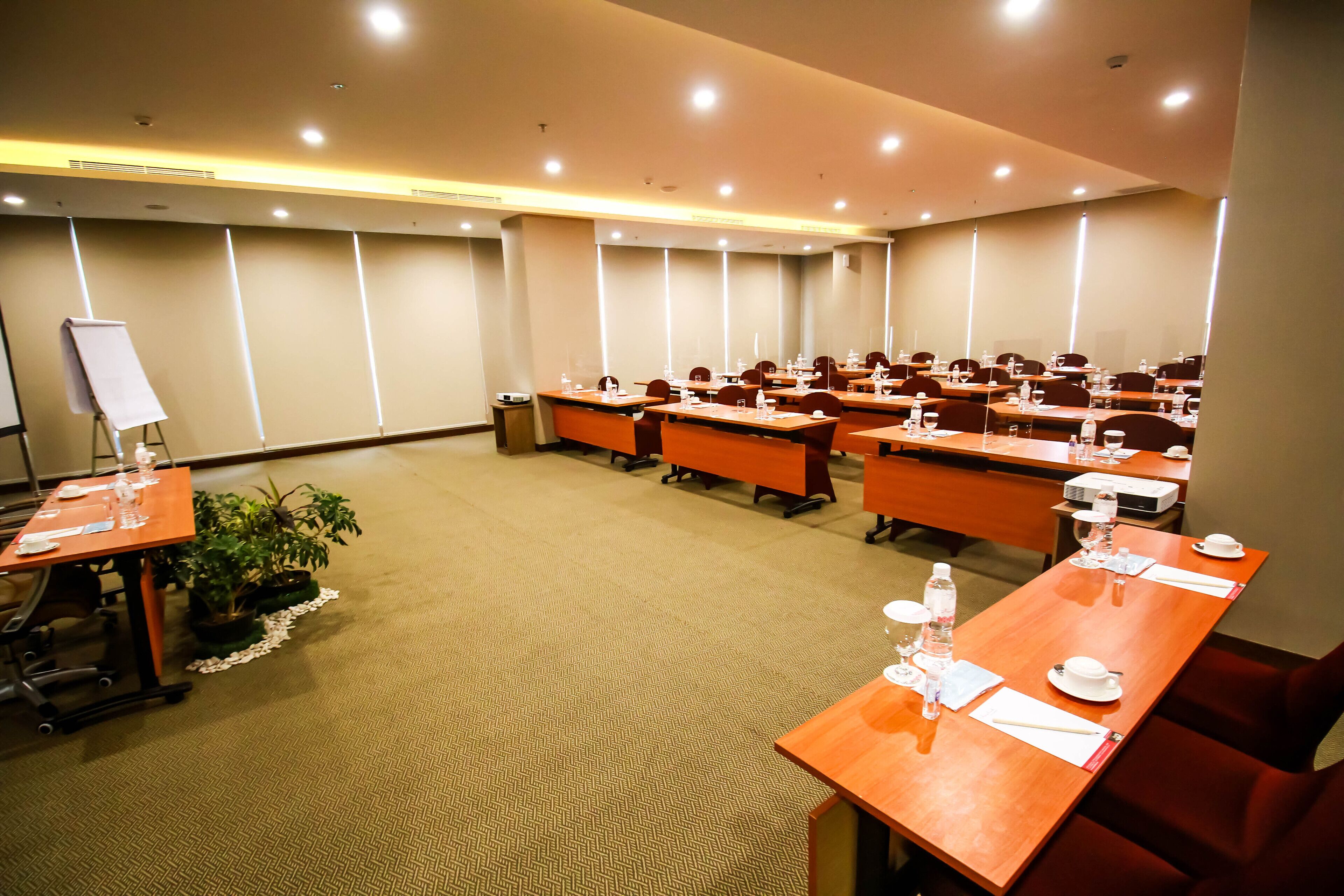 A conference room with multiple tables, chairs, and a whiteboard.