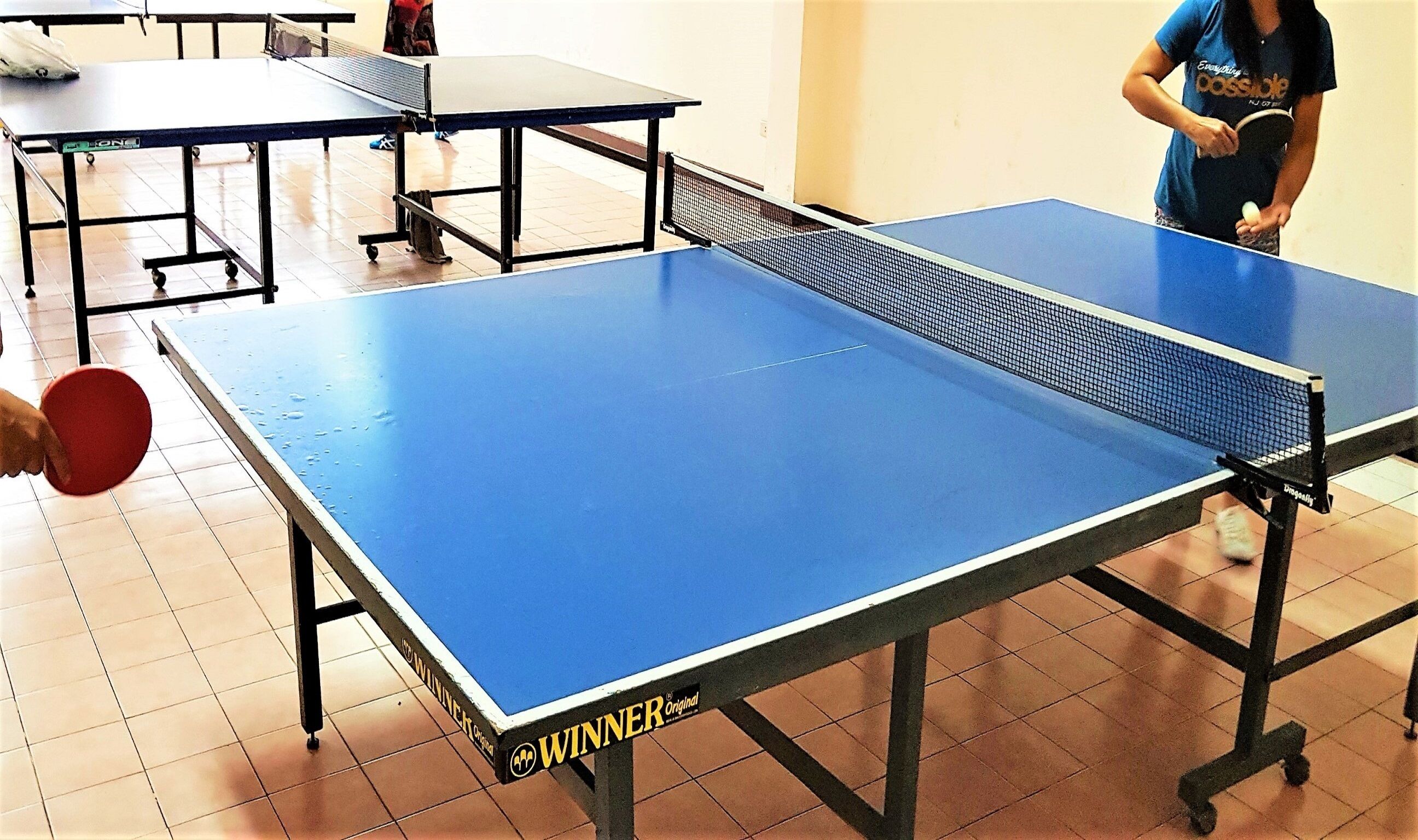 Une table de ping-pong avec une surface de jeu bleue et un filet.