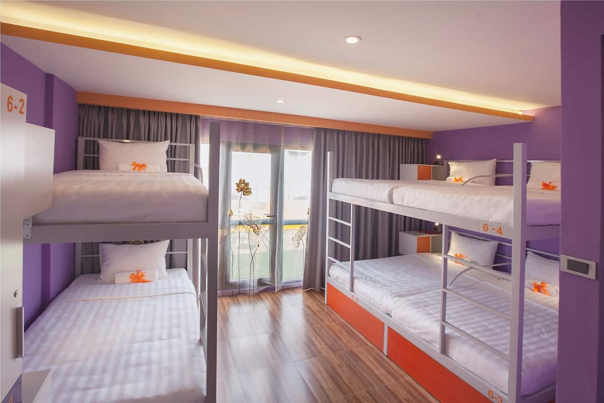 A room with bunk beds, a sliding door, and a small table.