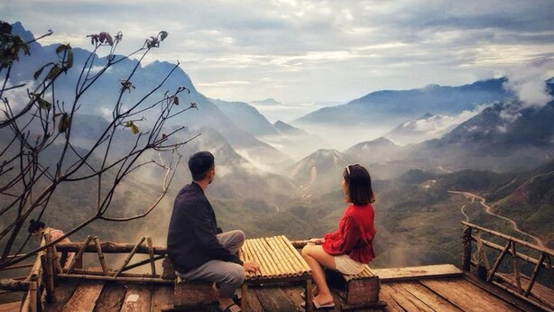 A couple sitting on a wooden bench overlooking a mountainous landscape. - Old Quarter View Hanoi Hostel (Hanoi)