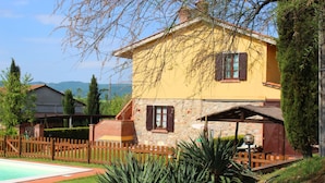 A two-story house with a stone facade and a yellow exterior.