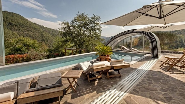 A poolside area with lounge chairs, a glass-enclosed hot tub, and a view of a mountainous landscape. - Villa La Massa - Exclusive Use - Heated Pool (Castel San Niccolo  -  Arezzo)