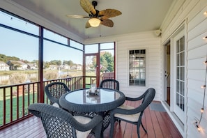 A covered porch with a round table and chairs, a ceiling fan, and large windows offering a view of a lake and houses. - Beautiful 2 story brick home on a cul-de-sac. A beautiful pond in the back yard (Poquoson)