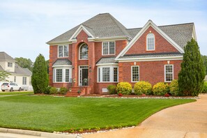 A two-story brick house with a front entrance, a driveway, and a well-maintained lawn. - Beautiful 2 story brick home on a cul-de-sac. A beautiful pond in the back yard (Poquoson)