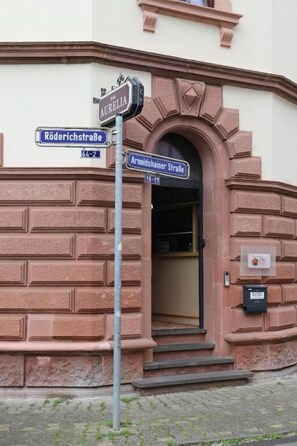 Entrada de un edificio con una señal de calle que indica 'Röderichstraße' y 'Arnoldshainer Straße'.