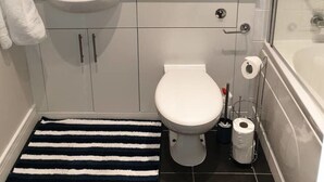 Une petite salle de bain comprenant un lavabo, des toilettes et une douche.