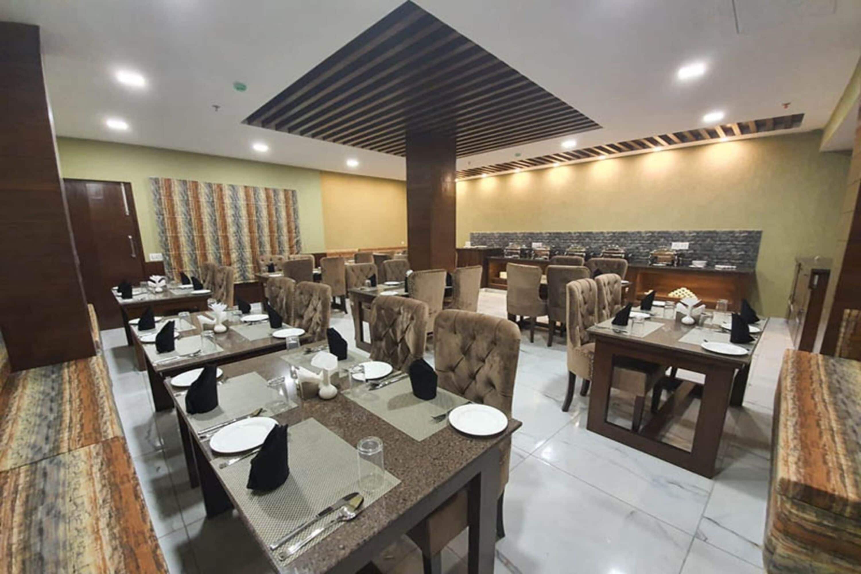 Un ristorante con diversi tavoli e sedie, una zona bar centrale e un muro decorato.