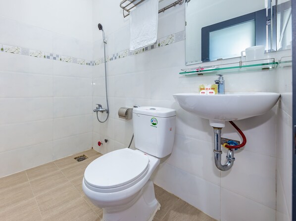 A modern bathroom with a toilet, shower, and sink.