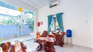 Una habitación con un ventanal grande, un dispensador de agua azul y un extintor.