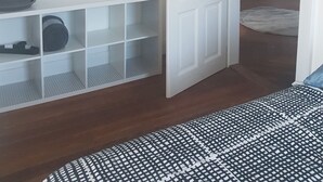 A room with a white door, a potted plant, and a white shelving unit. - Apartment 100 m² in a mansion (Munster)