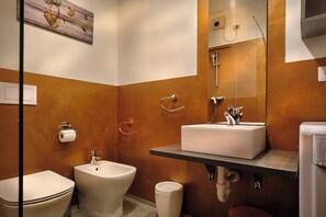 A bathroom with a bidet, toilet, and sink.