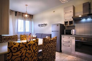 A modern kitchen with a built-in microwave, oven, and a stainless steel range hood.
