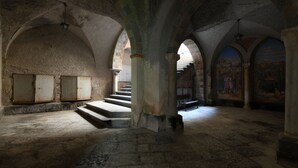 A dimly lit interior with arched ceilings and a staircase leading to an upper level. - Palazzo Gargano (Amalfi)
