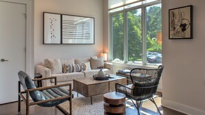 A modern living room with a sofa, chairs, a coffee table, and artwork on the walls.