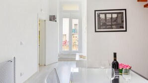 A modern interior with a glass table, a framed picture, and a bottle of wine. - GuestHost - Cute flat in the heart of Monopoli (Monopoli)