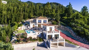 A multi-story villa with a swimming pool, surrounded by dense forest and a red pathway. - Secluded THE VIEW Villa ideal for 10 adults & 7 kids w/t pool (Nidri)