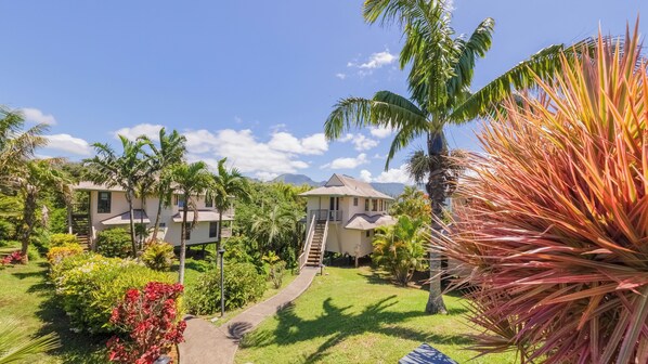 Een resort met meerdere gebouwen, een centrale trap en weelderige tropische begroeiing.