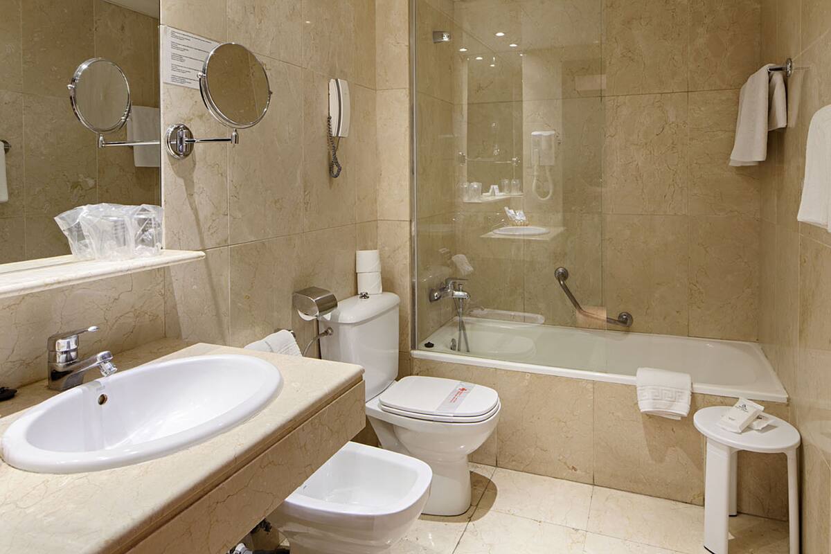 A modern bathroom with a sink, toilet, and bathtub.