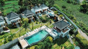 A residential area with multiple houses, a swimming pool, and lush greenery. - Mount Batur Villa (Kintamani)