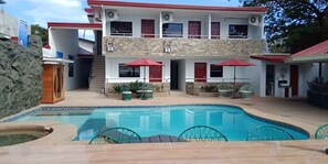 Un edificio de dos pisos con una piscina al frente.