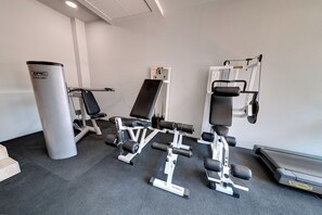 A gym with weight machines, a bench, and a treadmill.