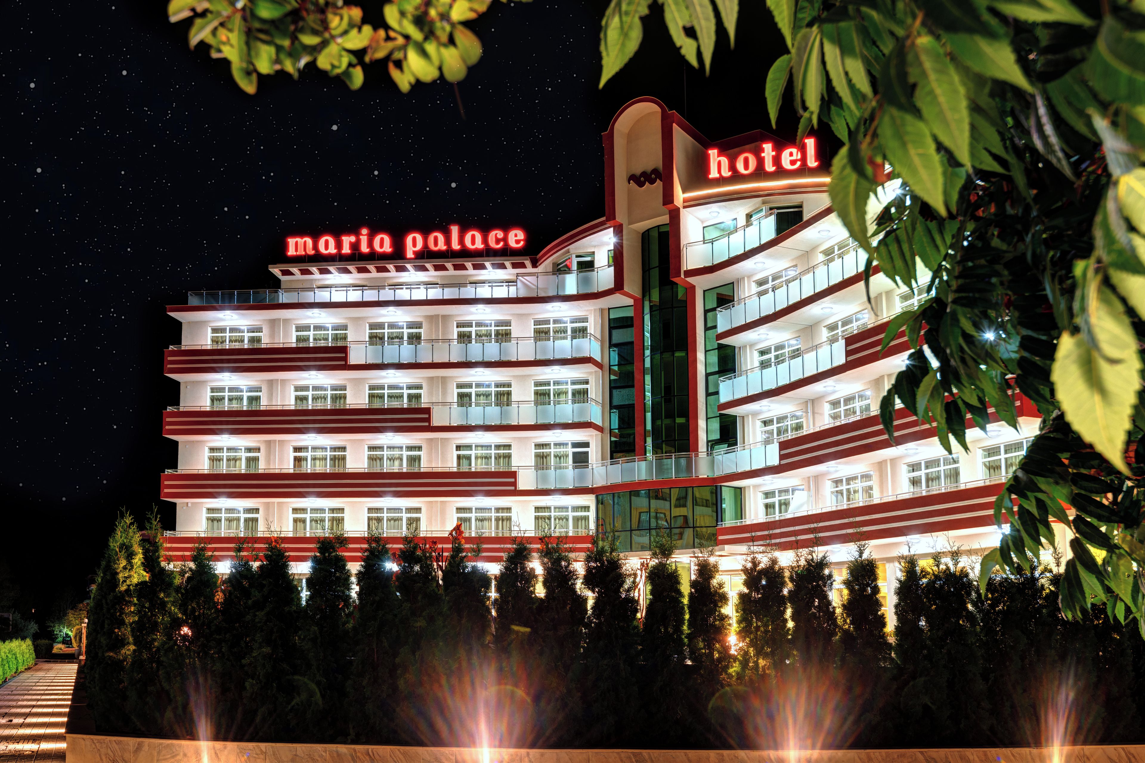 A multi-story hotel with balconies and a sign reading "Maria Palace Hotel".