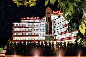 A multi-story hotel with balconies and a sign reading "Maria Palace Hotel".