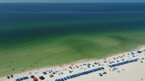 A beach with clear waters and a sandy shore.