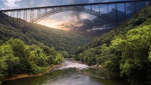A river with a bridge, surrounded by dense forest. - Romantic Get-away Cabin in the woods, w/Hottub next to coolest small town in USA (Victor)
