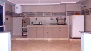 A kitchen with a central island, cabinets, a built-in oven, and a refrigerator. - Nice apartment by the lake 4579 (Bin El Ouidane)