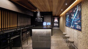 A modern inn with a reception desk, bar area, and a large map on the wall. - Minn Ueno Iriya (Tokyo)