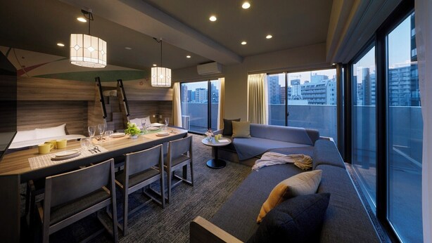 A modern hotel room with a dining area, a sofa, and a view of the city. - Minn Ueno Iriya (Tokyo)