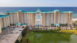 A large hotel with multiple floors, a central entrance, and a parking lot.