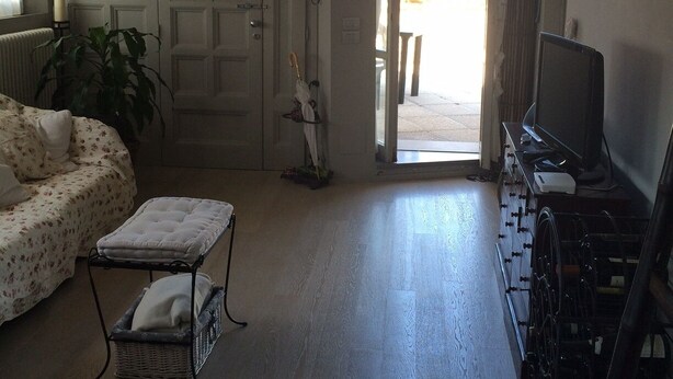 A living room with a sofa, a small table, a TV, and a wheelchair. - Rinidia Siena Celso Cittadini (Siena)
