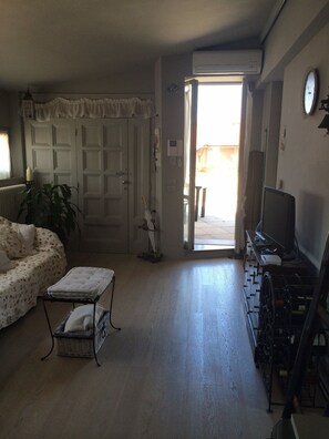 A living room with a sofa, a small table, a TV, and a wheelchair. - Rinidia Siena Celso Cittadini (Siena)