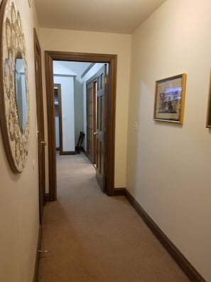 A hallway with a carpeted floor, wooden doors, and a framed picture on the wall. - South Park location that puts you near all of Dayton's attractions  (Dayton)