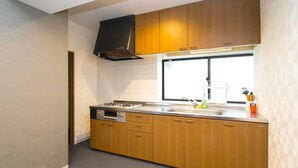 Una cocina moderna con armarios de madera, un lavamanos de acero inoxidable y una ventana sobre la encimera.
