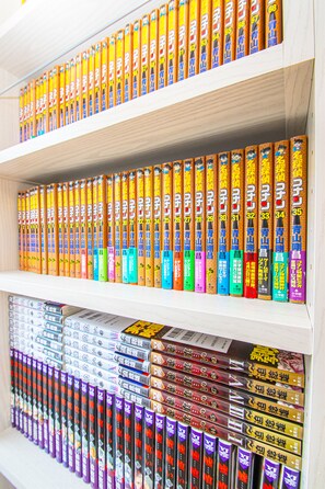 A bookshelf with multiple rows of colorful books. - AMP FLAT Itoshima (Fukuoka)